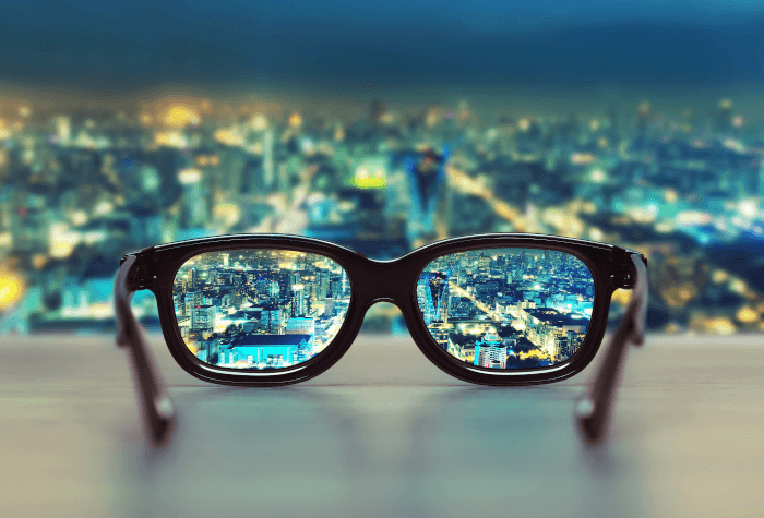 Black rimmed glasses focussed on night cityscape