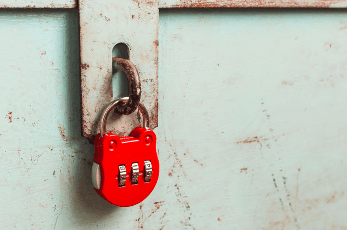 Red padlock on old green metal case