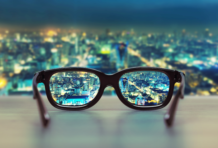 Black rimmed glasses focussed on night cityscape