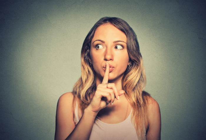 Woman putting finger to lips to keep a secret