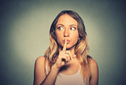 Woman putting finger to lips to keep a secret